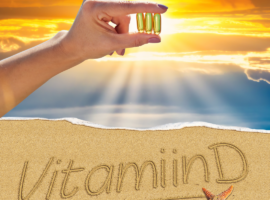 Vitamiin D3 kapslid päikesevalguses liivaranna taustal.