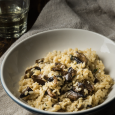 Vegan risoto shiitake seente ja valge mandlivõikreemiga taldrikul, kaunistatud värske peterselliga