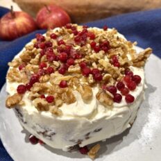 Kõrvitsa-õunakook toorjuustukreemiga, kaunistatud kreeka pähklite ja marjadega